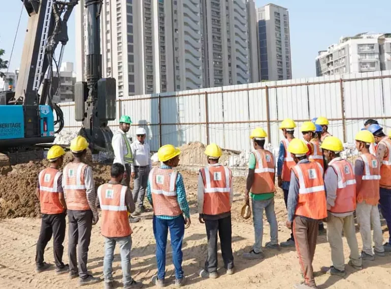 Two project managers/engineers in a conversation with workers on a construction site.