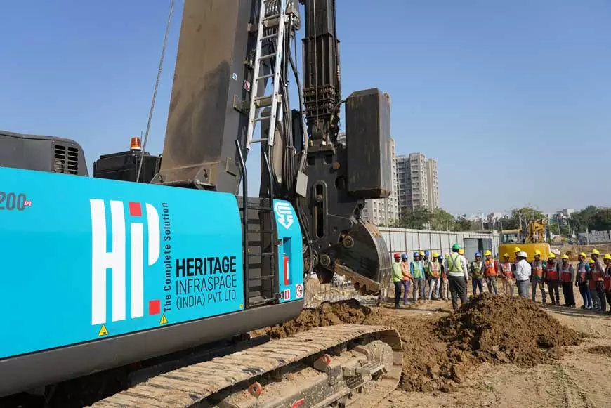 A group of people talking and understanding on how to work safely with heavy machinery on site.