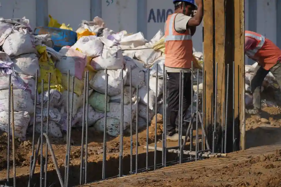 Two construction workers working on the excavated gap of a diaphragm wall construction site