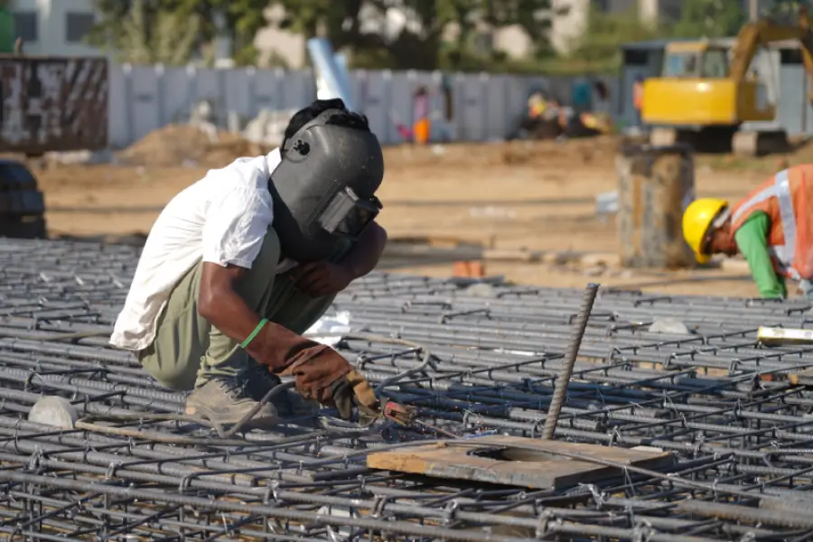 A welder welds steel rods to build the wall cage for diaphragm walls