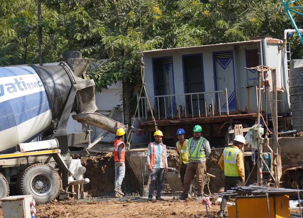 Three construction worked oversee a diaphragm wall construction in progress